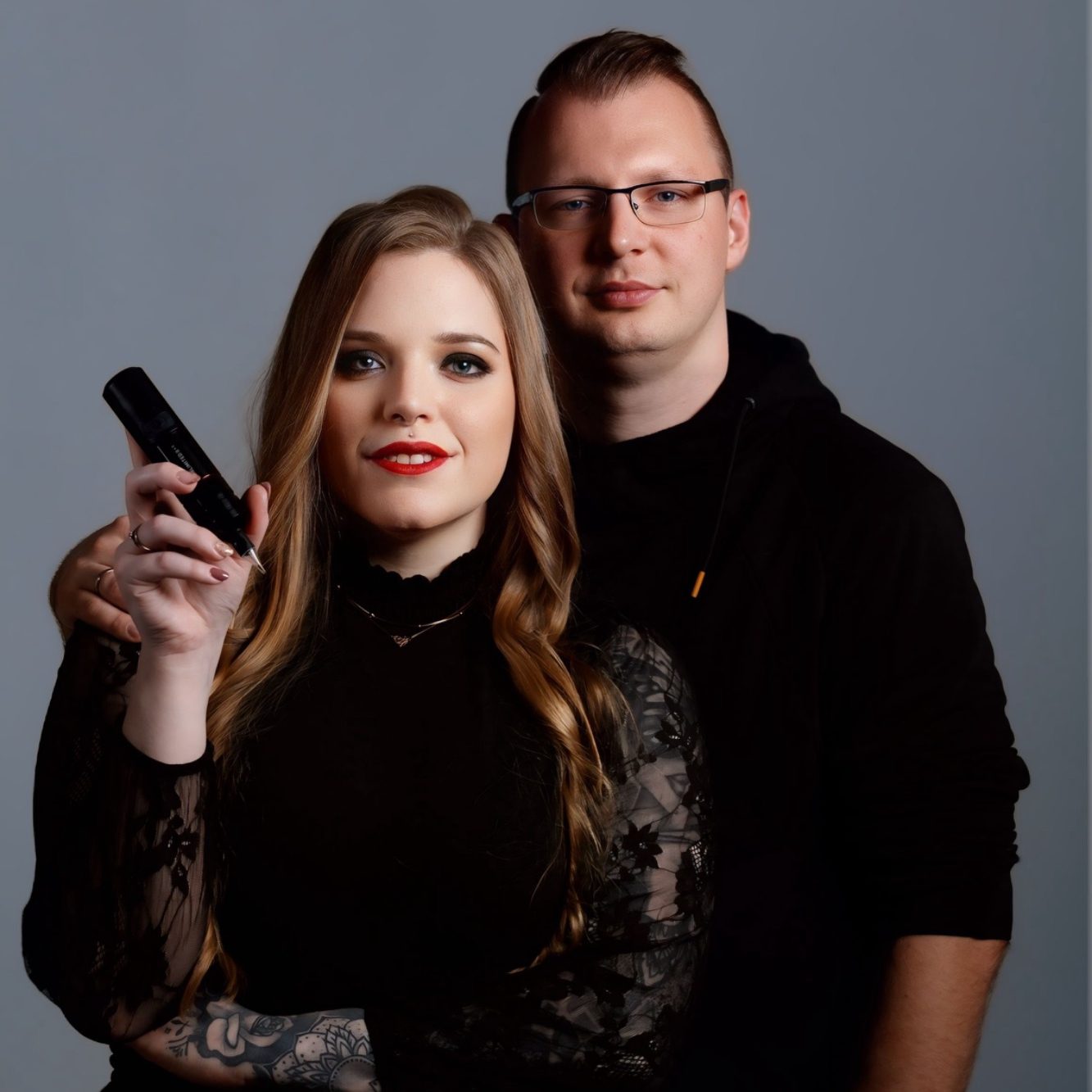 Alicia Funck mit Tattoomaschine steht vor ihrem Mann.