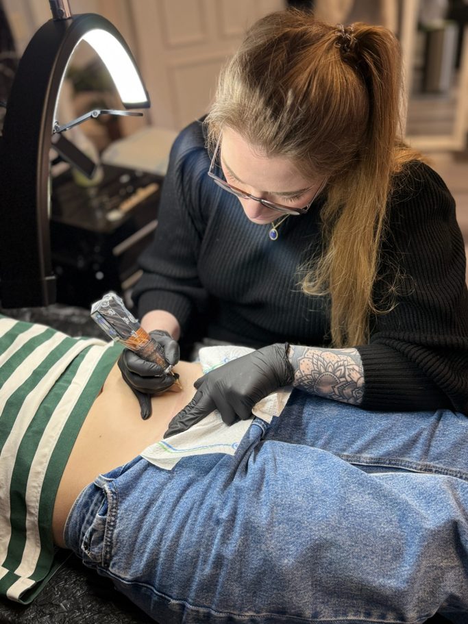 Alicia Funck beim Tätowieren an einer Narbe
