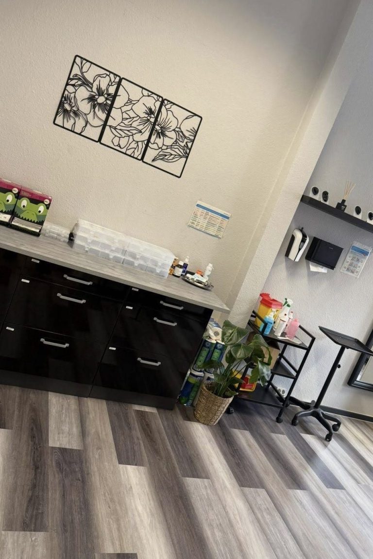 Ein moderner Raum mit Pflanzen und Kunst an der Wand. Zu sehen sind Tattooutensilien.