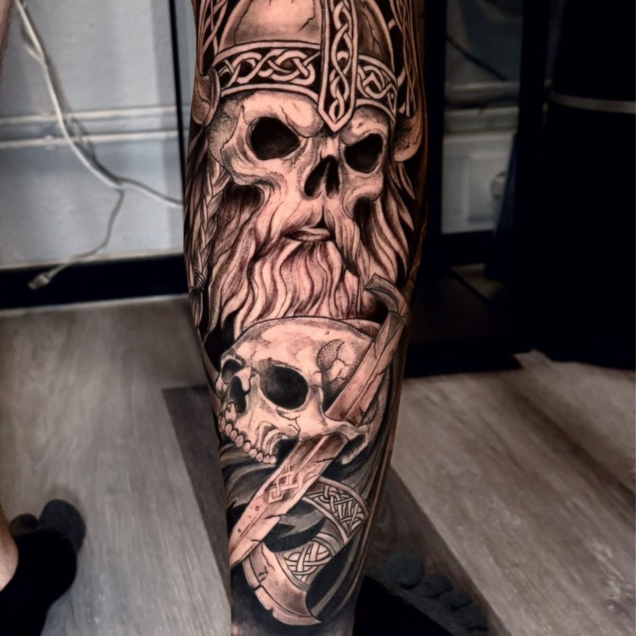 Schädel mit Bart und Helm, umgeben von einem weiteren Schädel und einem Schwert.