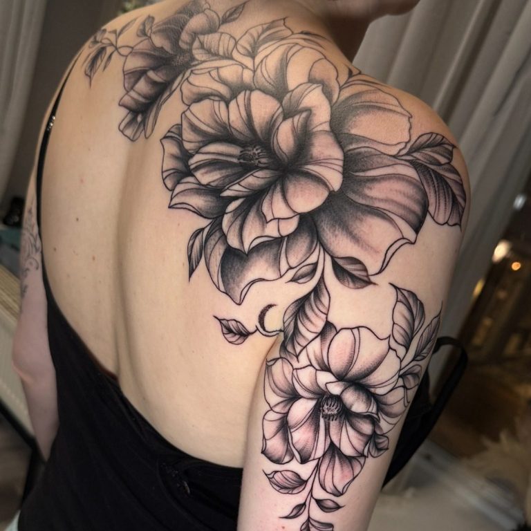 Schwarzes Tattoo mit großen, detaillierten blühenden Blumen auf dem Rücken.